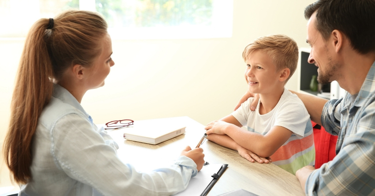 Young man and his son meeting with headmistress at school